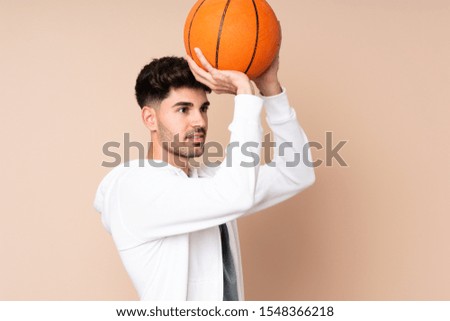 Young man over isolated background playing basketball