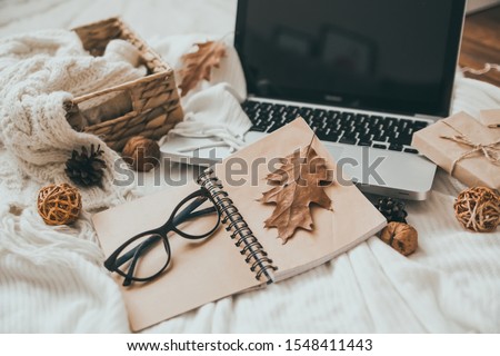 Sweaters and cup of tea with notebook, laptop and knitting clothes. Cozy autumn or winter concept. 