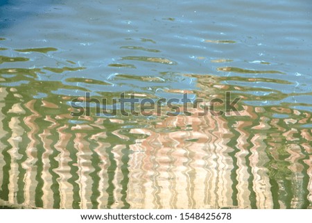 Blurry reflections  on the river surface on a sunny day