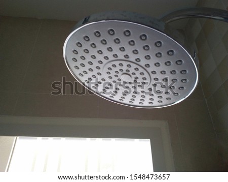Closeup of the shower head in the bottom view On a gray wall background and with glass wall lighting. With copy space