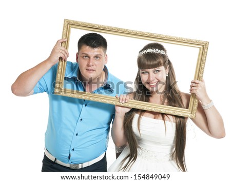portrait of the bride and groom are posing with the big frame on white background
