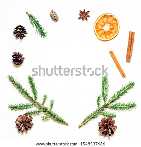Christmas frame composition. Fir branches, star anise, dried orange, cinnamon on white background. Flat lay, top view, copy space.
