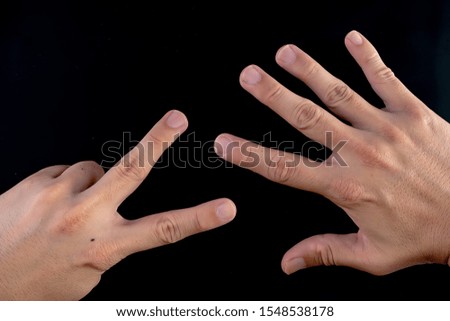 Hand symbols on black background, for drawing or used to communicate, paper and scissors
