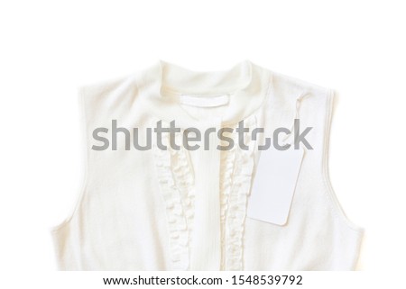 Brand label, blank price tag on white  women's knitting clothes, elegant blouse with scarf and ruffles decor