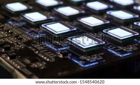 The process of checking several oled displays on the test station. Displays glow brightly of white color.Microelecronics.Display and light panel technology. Royalty-Free Stock Photo #1548540620
