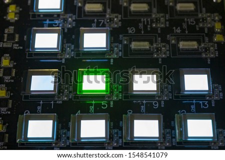 The process of checking several oled displays on the test station. Displays glow brightly of green and white color.Microelecronics.Display and light panel technology.