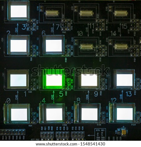 The process of checking several oled displays on the test station. Displays glow brightly of green and white color.Microelecronics.Display and light panel technology.
