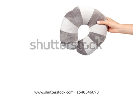 Hand with travel pillow, gray colored, soft and puffy. Isolated on white background. Copy space template, mockup.