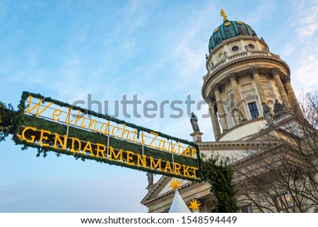 Entrace welcome sign of Gendarmenmarkt Christmas Market in Berlin, Germany. One of the most famous Christmas market in Europe. French Church (Franzosischer Dom) on background