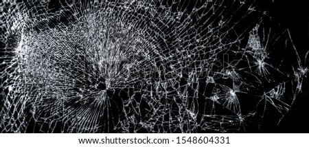 Broken phone screen, large cracked glass on a black background
