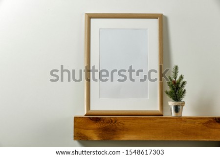 Wooden shelf of free space for your decoration. White background of wall. Christmas composition with frame and empty space for your photo. Winter time. Copy space. 