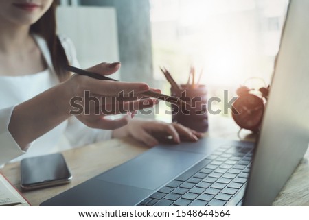 Young women holding pen and using computer laptop for using design or creative  to drawing Draw clothes design. freelance at work concept.