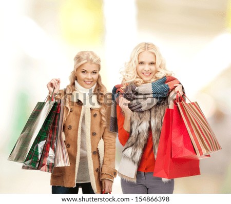retail and sale concept - happy women in winter clothes with shopping bags