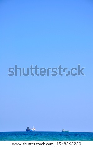 Two transport ships on the horizon with blue sky in the background during vacation in Cyprus