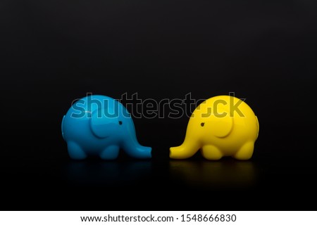 tow yellow and blue elephants isolated on black background 