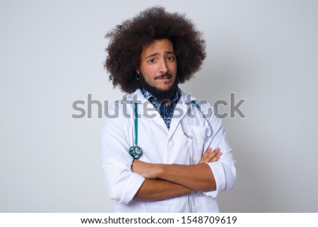 Isolated portrait of stylish young African American doctor man bitting  mouth and looking worried and scared crossing arms, worry and doubt.