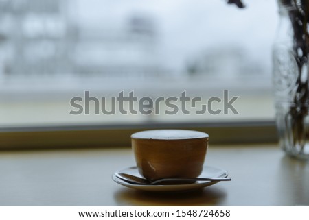 Cup of coffe with milk on a dark background. Hot latte or Cappuccino prepared with milk on a wooden table with copy space Royalty-Free Stock Photo #1548724658