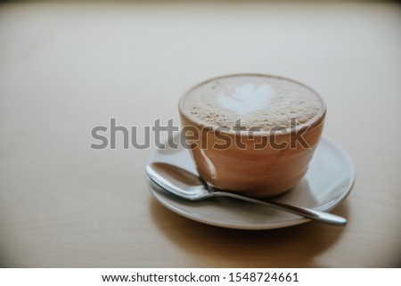 Cup of coffe with milk on a dark background. Hot latte or Cappuccino prepared with milk on a wooden table with copy space Royalty-Free Stock Photo #1548724661