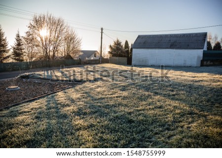 A plot of land with a lawn for the construction of a new house or territory for grazing farm animals in a frosty sunny morning