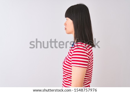 Young beautiful chinese woman wearing red striped t-shirt over isolated white background looking to side, relax profile pose with natural face and confident smile.