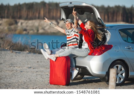 Young married couple in vacation. Journey on the car. Car trip. Emotional young people traveling.