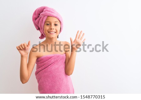 Beautiful child girl wearing shower towel after bath standing over isolated white background showing and pointing up with fingers number six while smiling confident and happy.