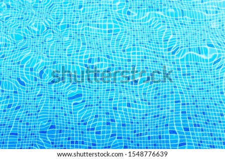 Ripples on the surface of the water in a blue swimming pool.
