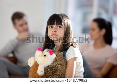 Sad little girl feel upset lonely hug fluffy toy hedgehog friend affected by parent fight or quarrel, upset small child loner stressed with mom and dad divorce or split, family problems concept Royalty-Free Stock Photo #1548779852