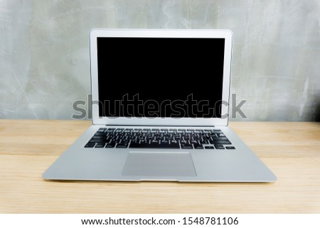 digital notebook blank screen  on a wooden table with grey background. 