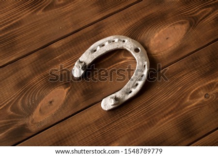 Silver horseshoe on a wooden table. An old horseshoe