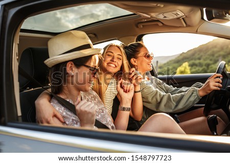 Three best female friends travel together.They drives a car and making fun.Summer adventure