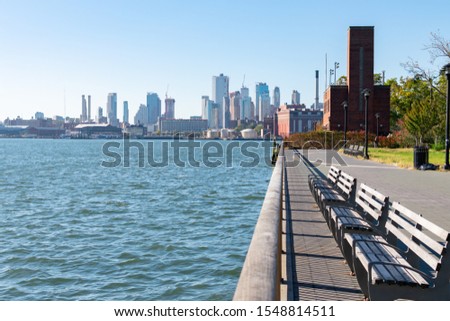 Park with Empty Benches on the Lower East Side in New York City along the East River and near the Williamsburg Bridge with the Downtown Brooklyn Skyline