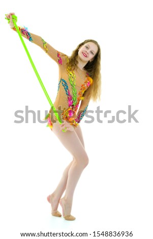 A girl gymnast performs exercises with a skipping rope.