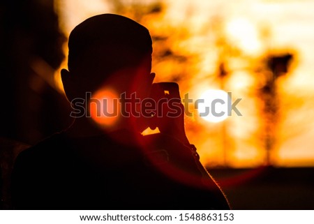 silhouette man photographing at sunset
