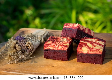 Red velvet cream cheese brownies on wooden plate Royalty-Free Stock Photo #1548864002