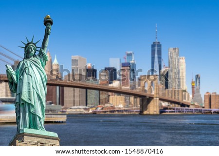 Statue of Liberty with background of Brooklyn bridge and Lower Manhattan skyscrapers bulding for New York City in New York State NY , USA
