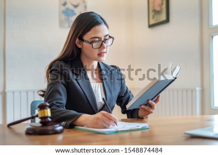Young lawyer asian woman reading book in lawyer office.