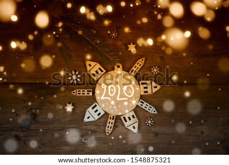 christmas and new year 2020  card with fir branch and ball from wooden tree decorations/winter holidays concept