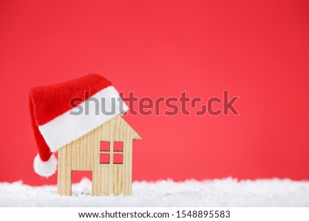 Santa hat with house model on red background
