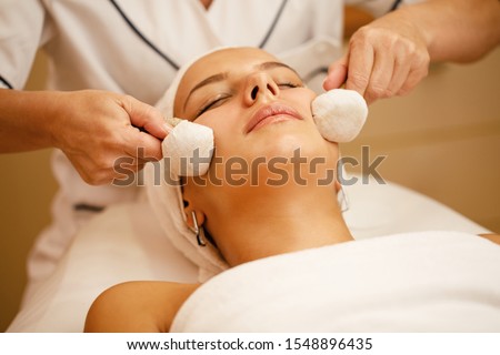 Close-up of beautiful woman enjoying in facial massage with Thai herbal compress at spa salon.  Royalty-Free Stock Photo #1548896435