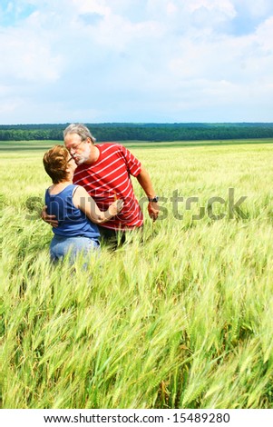 Senior couple kissing in a wheat field