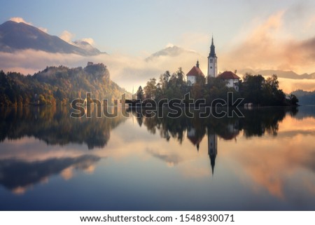 Stunning sunrise on Bled lake in Slovenia with the Pilgrimage Church of the Assumption of Maria and Bled castle in the background