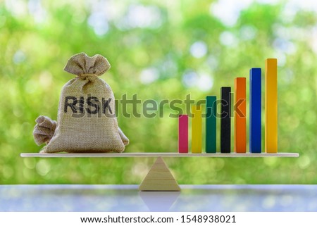 Financial leverage and risk management concept : Rising bar graph and risk bags on a basic balance scale, depict the best use of capital based on risk tolerance and willingness to use borrowed fund Royalty-Free Stock Photo #1548938021