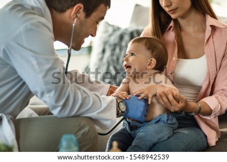 Happy baby boy having fun while doctor is listening his heartbeat with a stethoscope. Royalty-Free Stock Photo #1548942539
