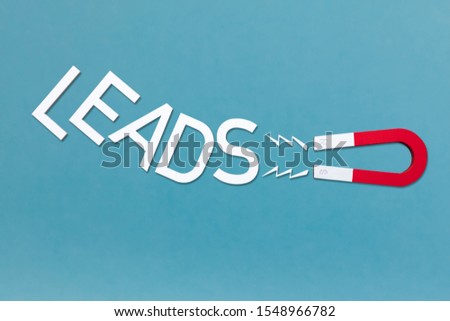 An Elevated View Of Magnet Attract The White Text Leads On Blue Backdrop Royalty-Free Stock Photo #1548966782