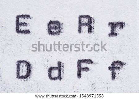 Real typewriter font alphabet with letters E, R, D, F on white paper. Macro shot