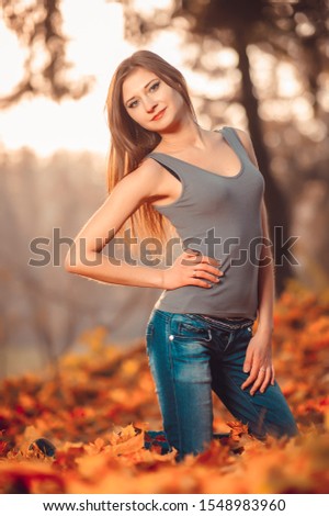 Girl in a gray blouse, jeans in the autumn forest