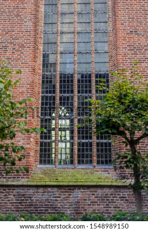 Red brick wall, trees and windows of Church in Hoorn, North Holland, Netherlands 