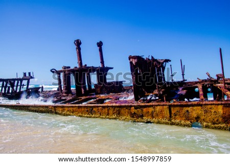 Photograph of the shipwreck of the SS Maheno on Fraser Island with a cloudless sky in the background. Fraser Island is located off Queensland in eastern Australia