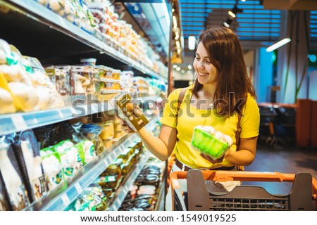 young pretty adult woman do shopping in grocery store Royalty-Free Stock Photo #1549019525